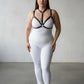 Plus-size black elastic body harness set worn over a white bodysuit with ring accents