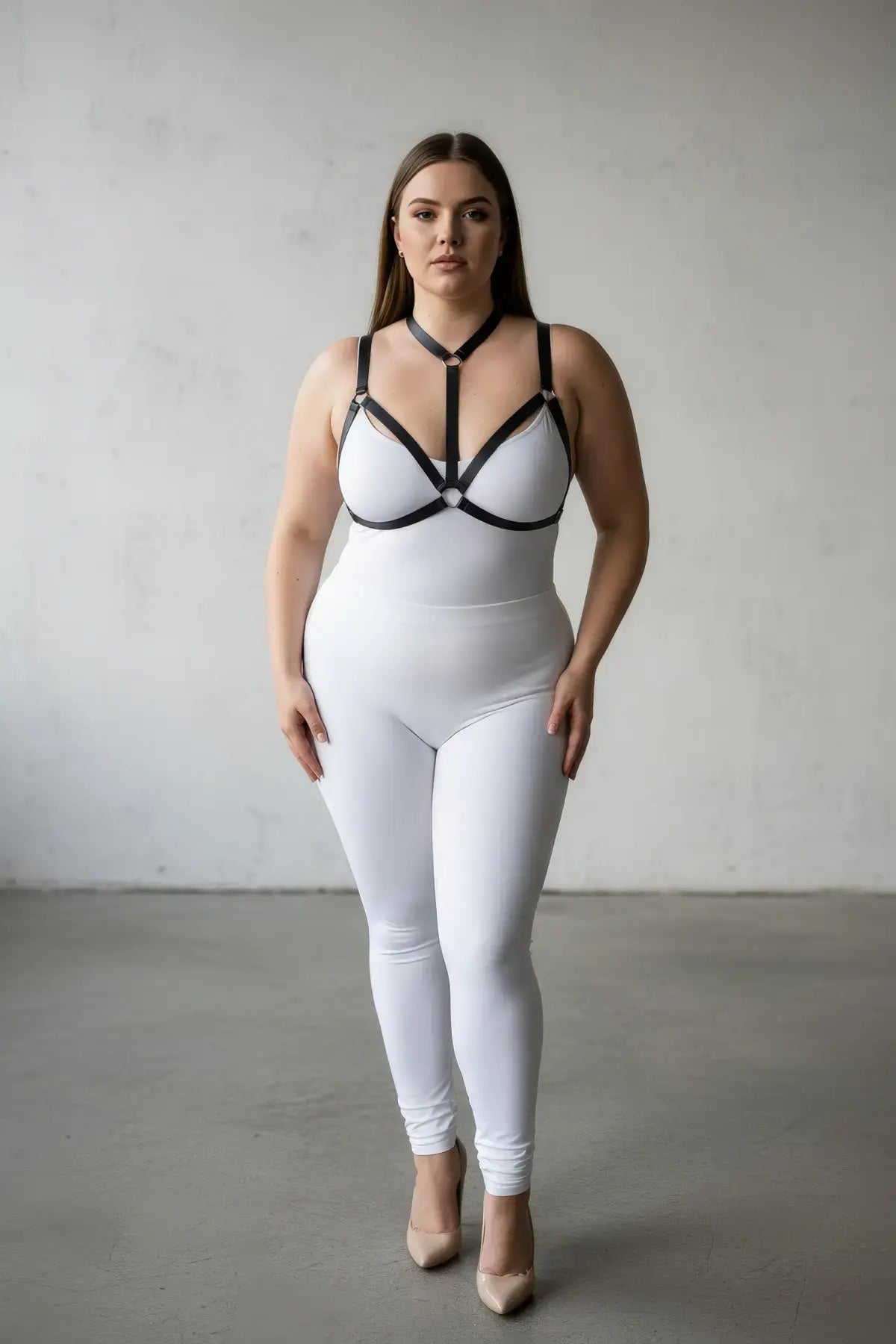 Plus-size black elastic body harness set worn over a white bodysuit with ring accents