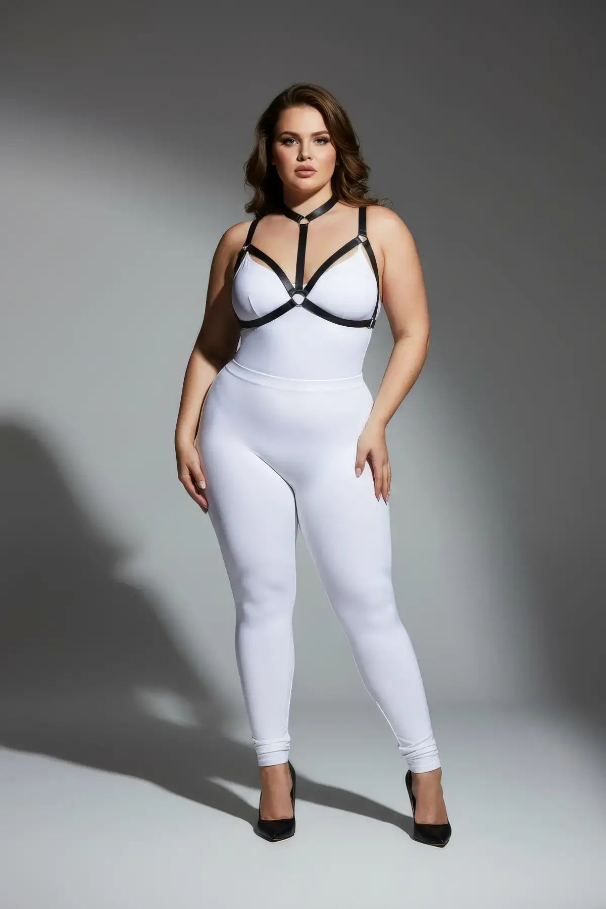 Plus-size multi-colour elastic body harness set worn over a white bodysuit with black vegan straps by HarnessClub
