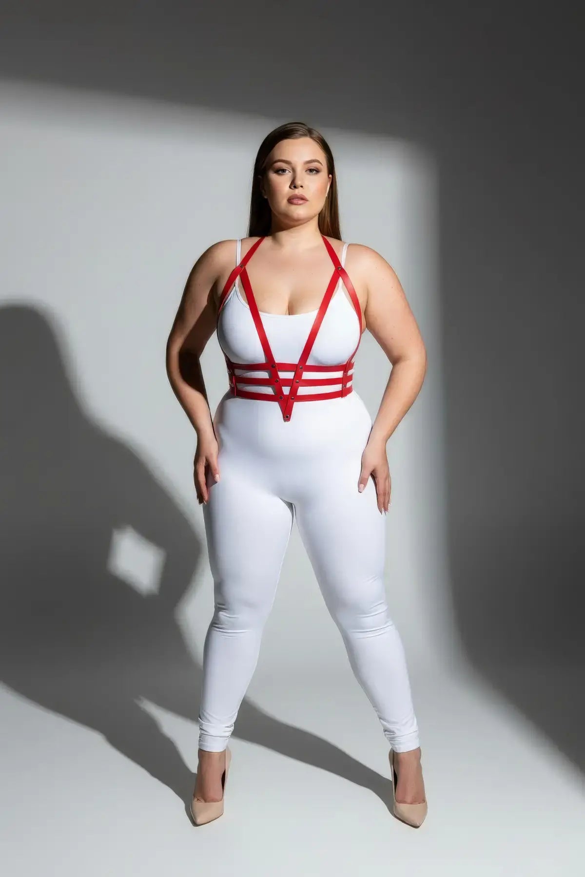 Plus Size Red Adjustable Faux Leather Body Harness Set by HarnessClub worn over a white bodysuit.