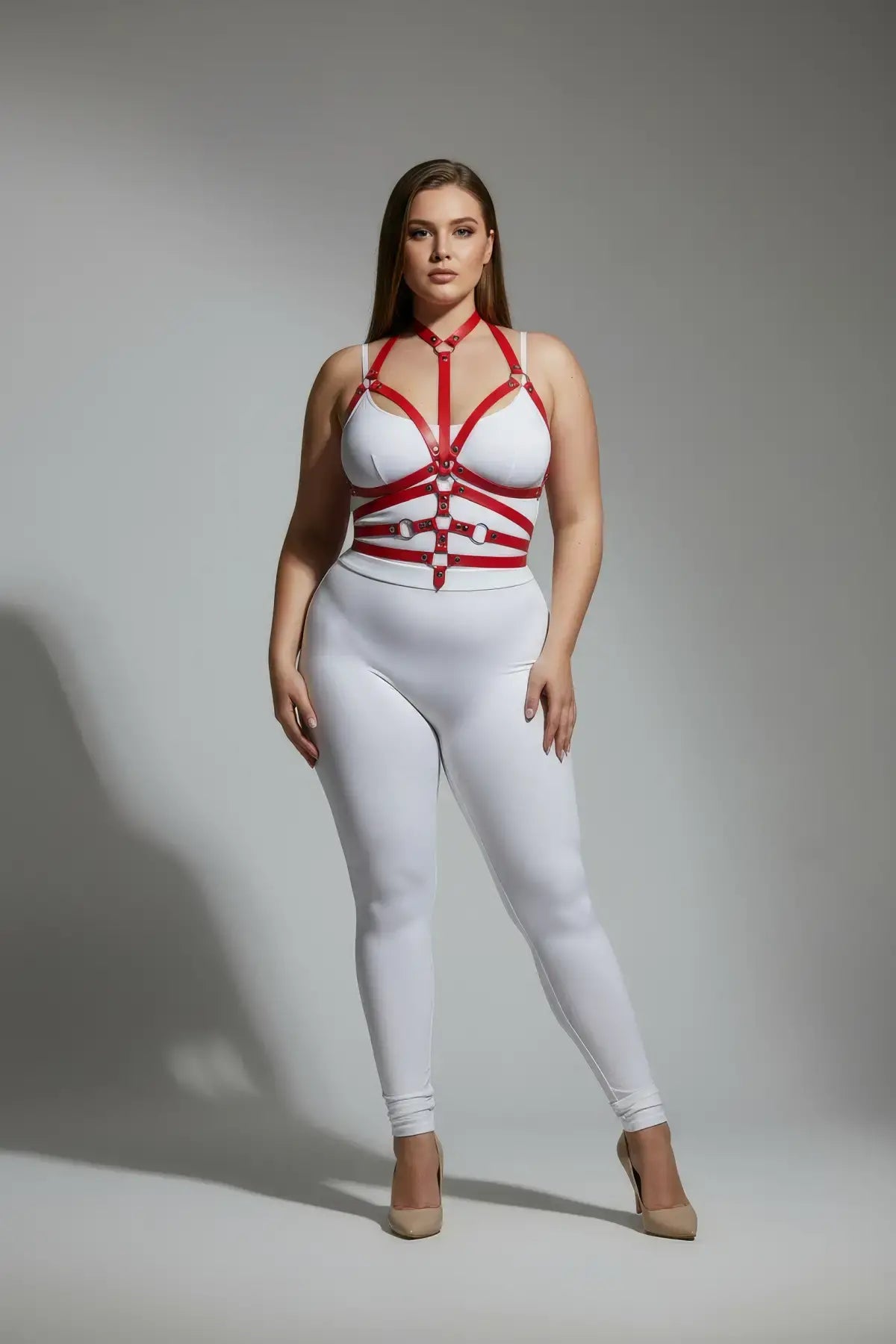 Plus-size red adjustable full-body faux leather harness on white bodysuit.