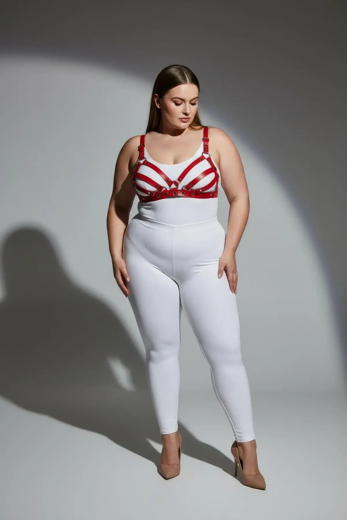 Plus-size red faux-leather bra-style harness set by HarnessClub worn over a white top