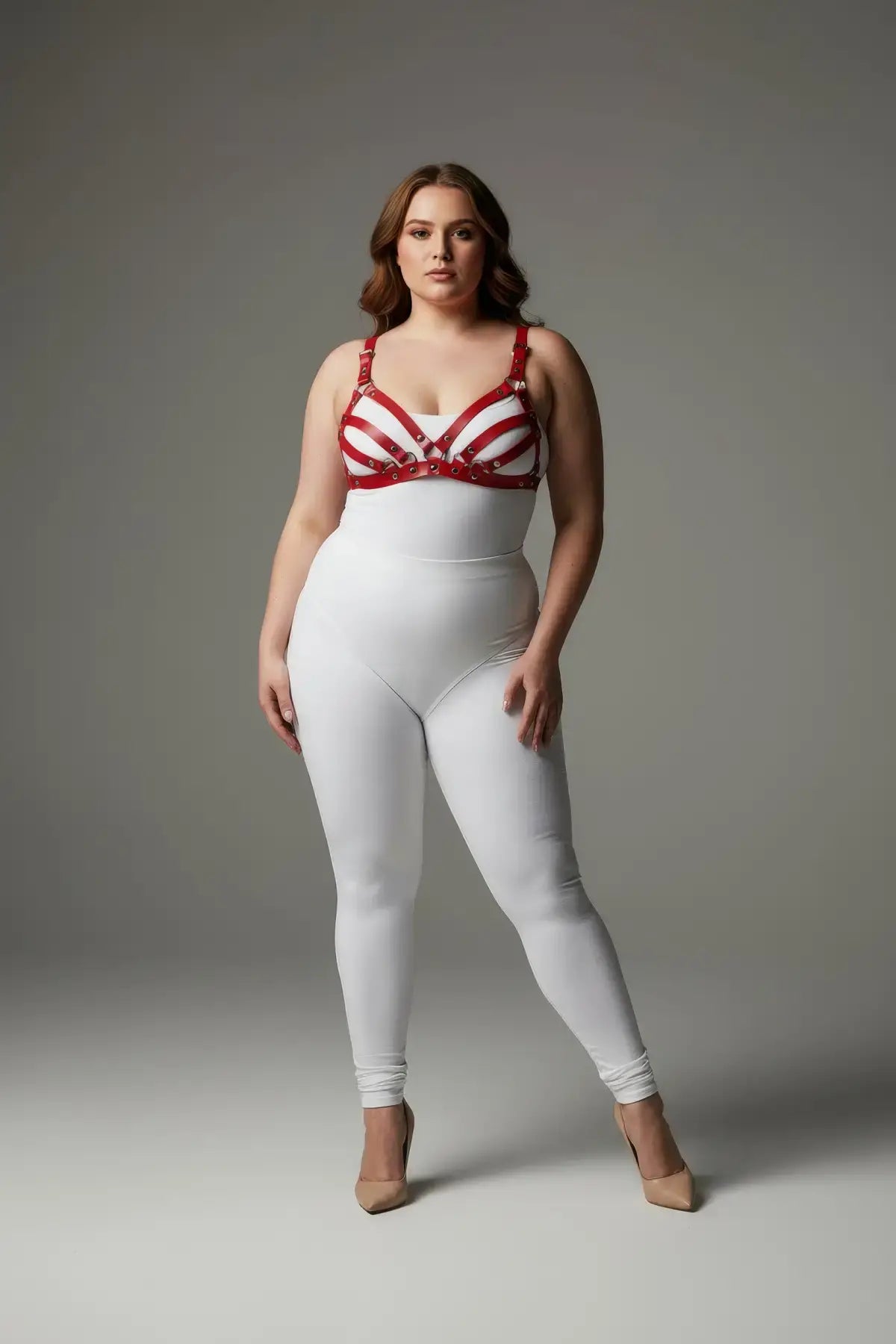 Plus-size red bra-style faux leather harness set worn by a model in a white bodysuit