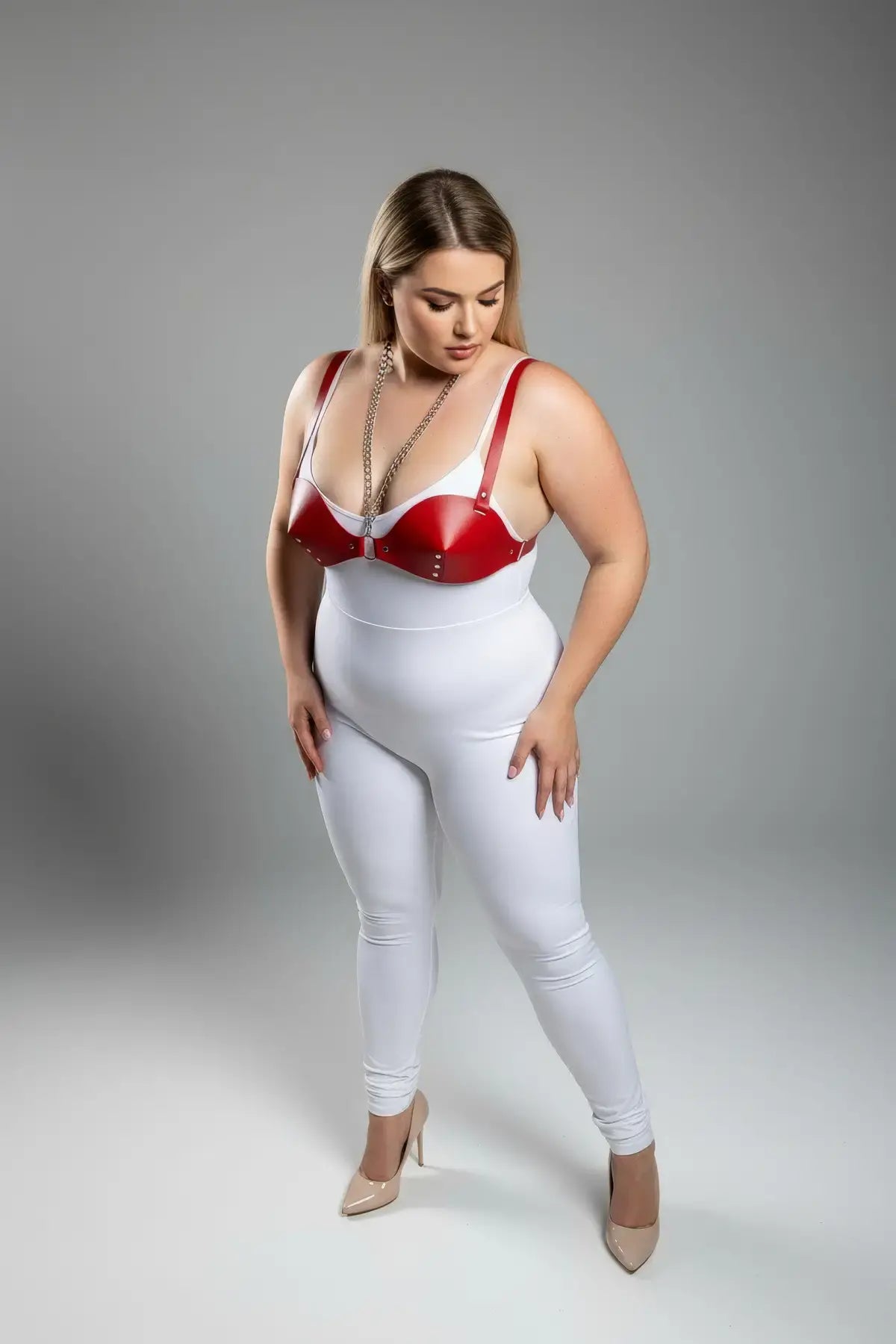 Plus size red faux-leather chest harness with chain detail worn over a white bodysuit