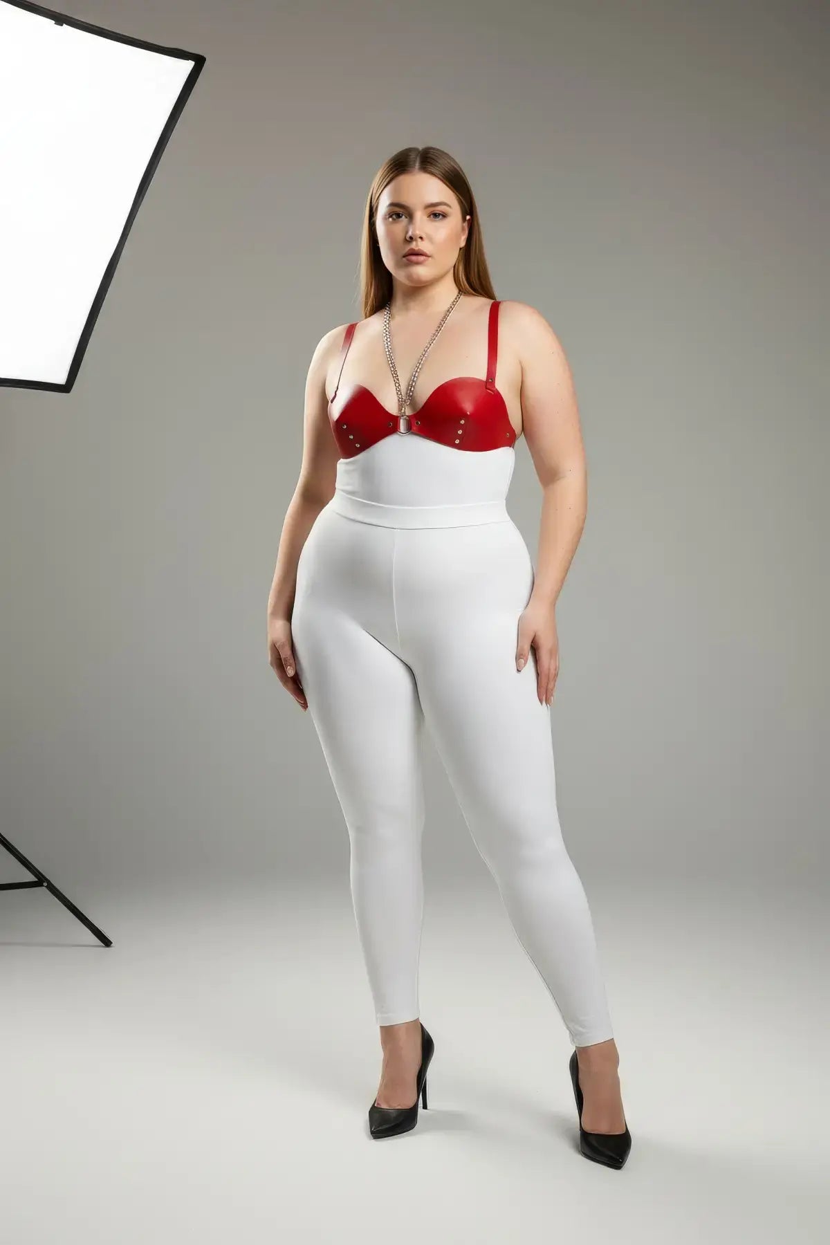HarnessClub plus-size red faux-leather chest harness with two chain-and-stud accents.