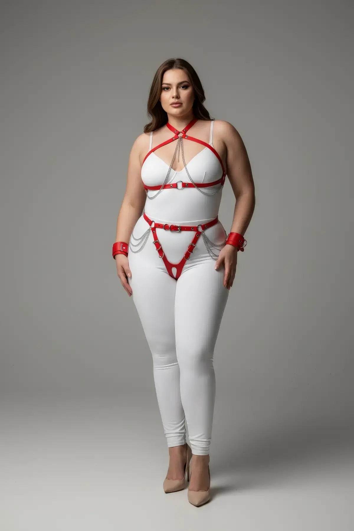 Plus-size red chain-detail faux leather harness set by HarnessClub; worn over white bodysuit with silver chains.
