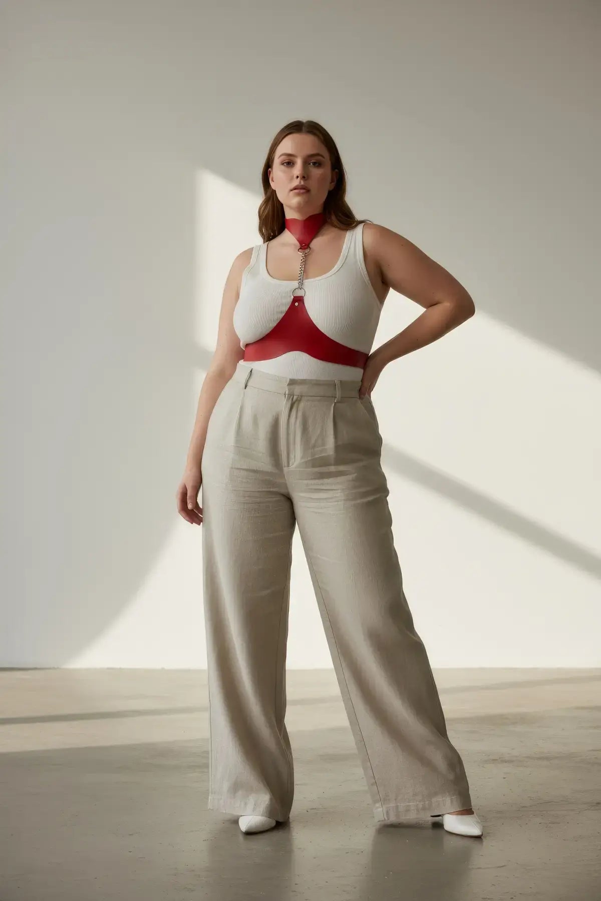 Plus size red chain-detail leather body harness worn over a white tank top