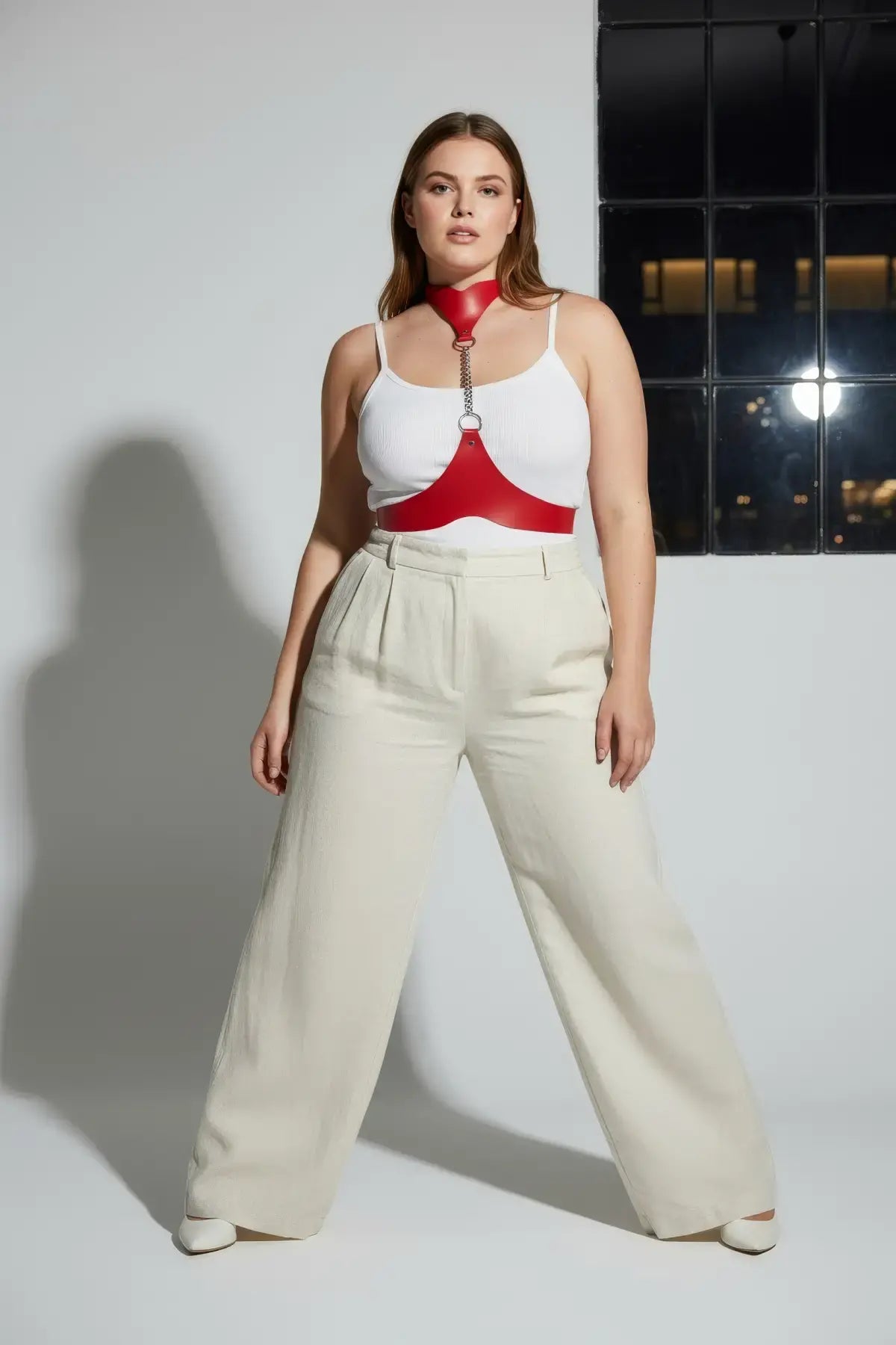 Plus-size red leather body harness with chain detail by HarnessClub worn by model