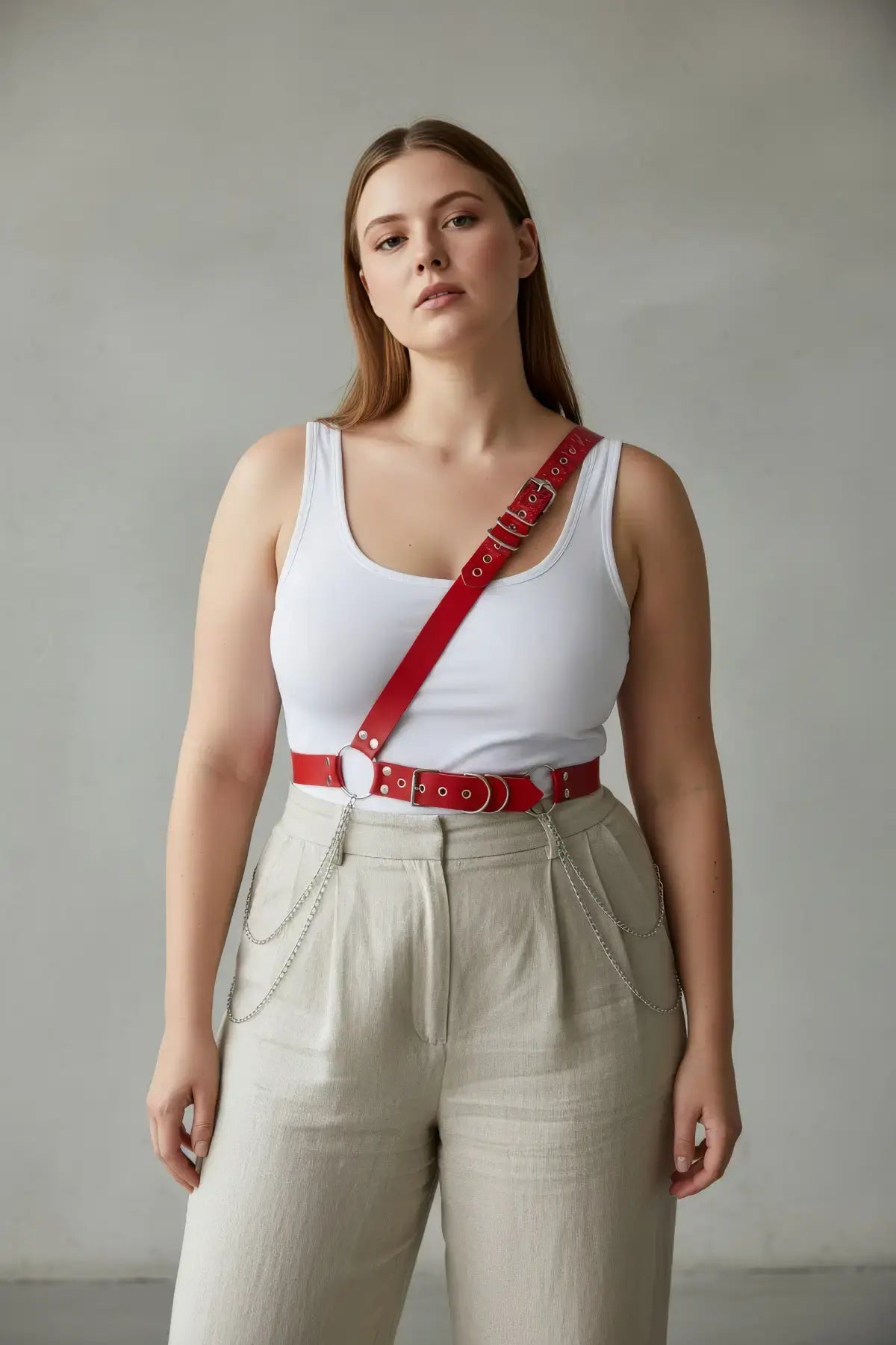 Plus Size Red Leather Harness with Chain Detail by HarnessClub worn diagonally across the torso over a white tank top