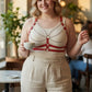 Plus-size red vegan-leather cage chest harness with silver chains worn by model