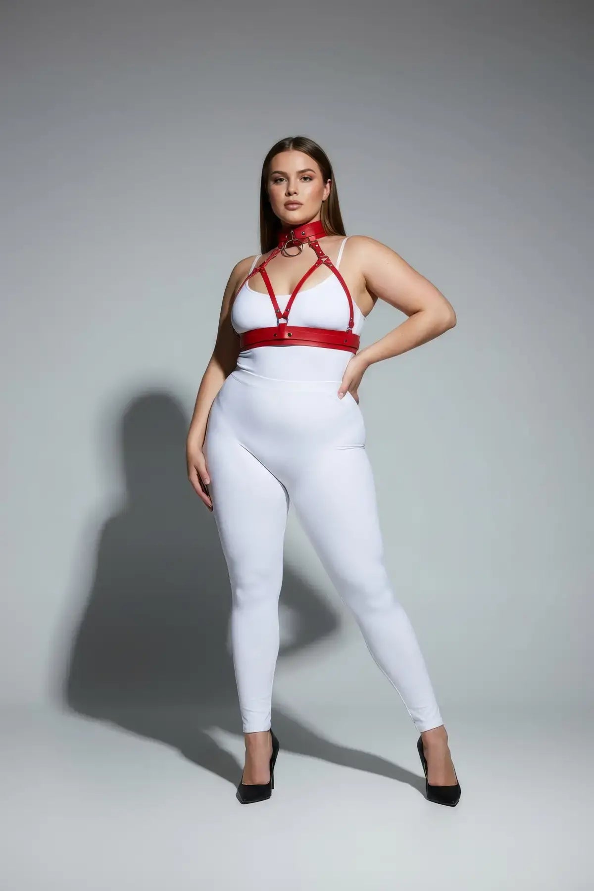Plus-size red faux leather collar-detail harness set worn over a white bodysuit, front view