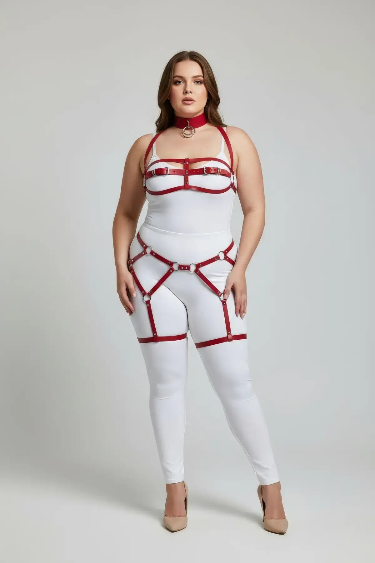 Plus-size red vegan leather complete garter body harness worn over a white bodysuit with chest and leg straps
