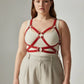 HarnessClub plus-size red leather body harness with corset-detail straps and metal rings.
