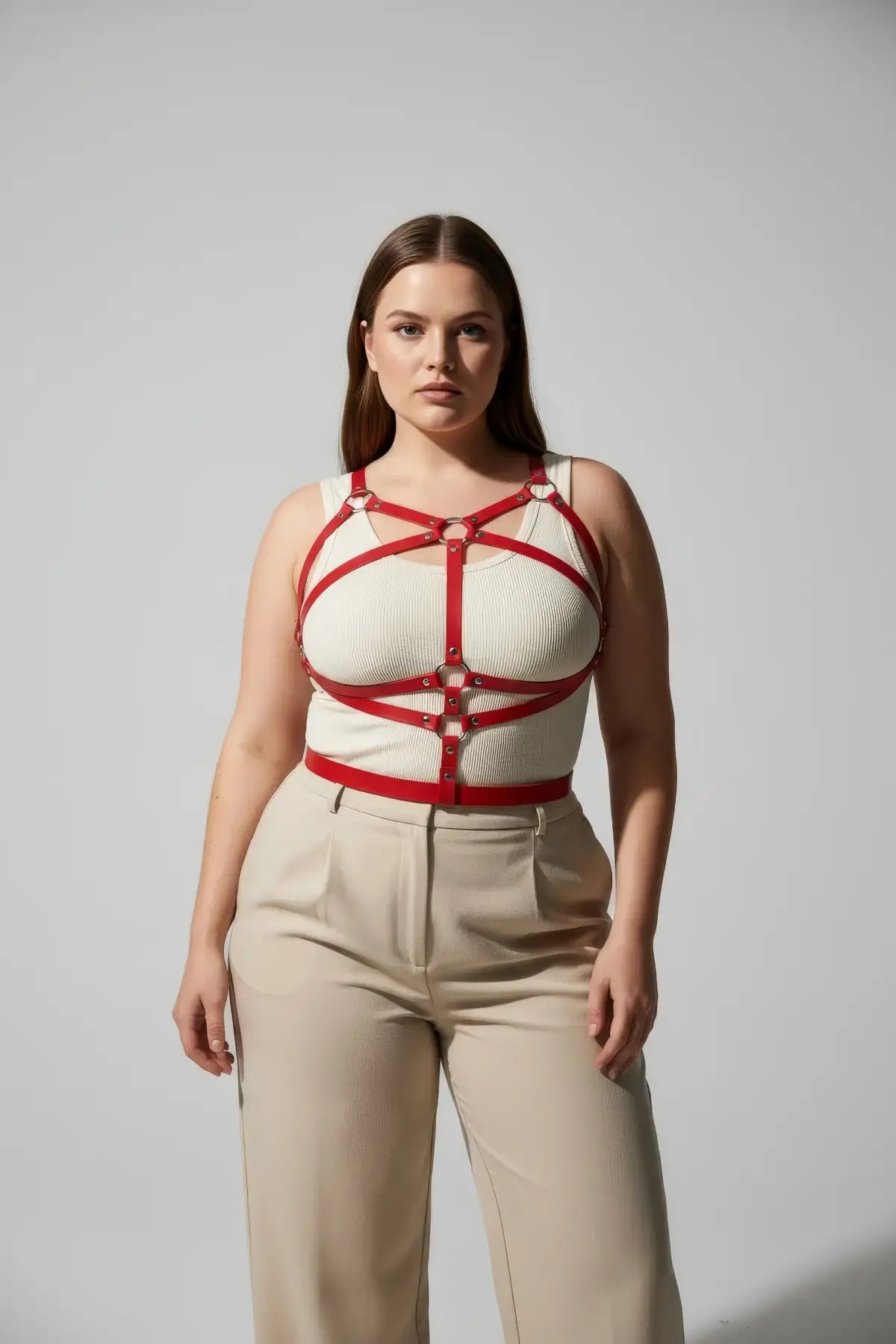Plus-size red leather corset-detail body harness worn over a white ribbed tank top, HarnessClub