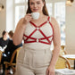Plus-size red leather harness with corset-style straps over a white tank top.