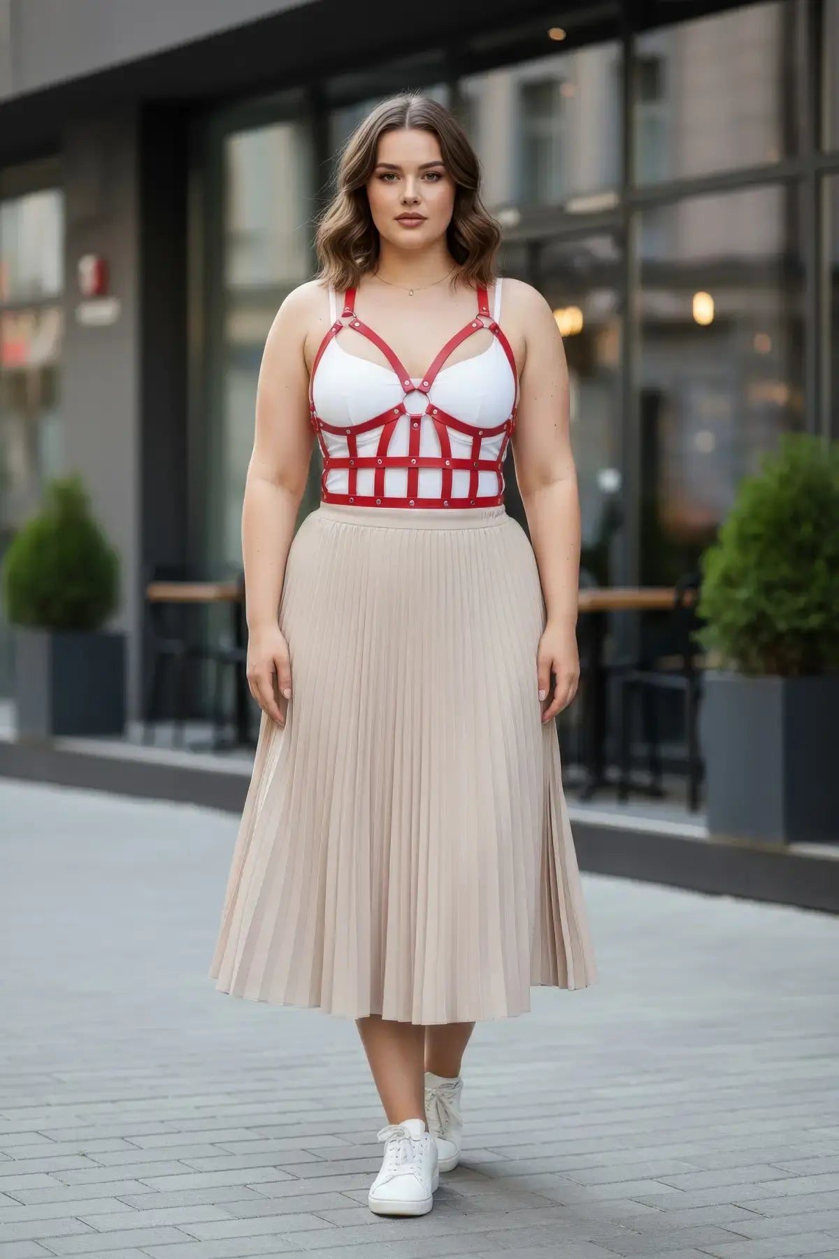 Plus-size red leather corset-style body accessory by HarnessClub worn over a white top.