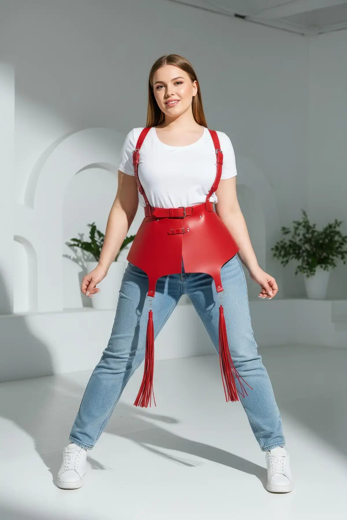 Plus-size red vegan-leather corset suspender harness with tassels worn over a white T-shirt