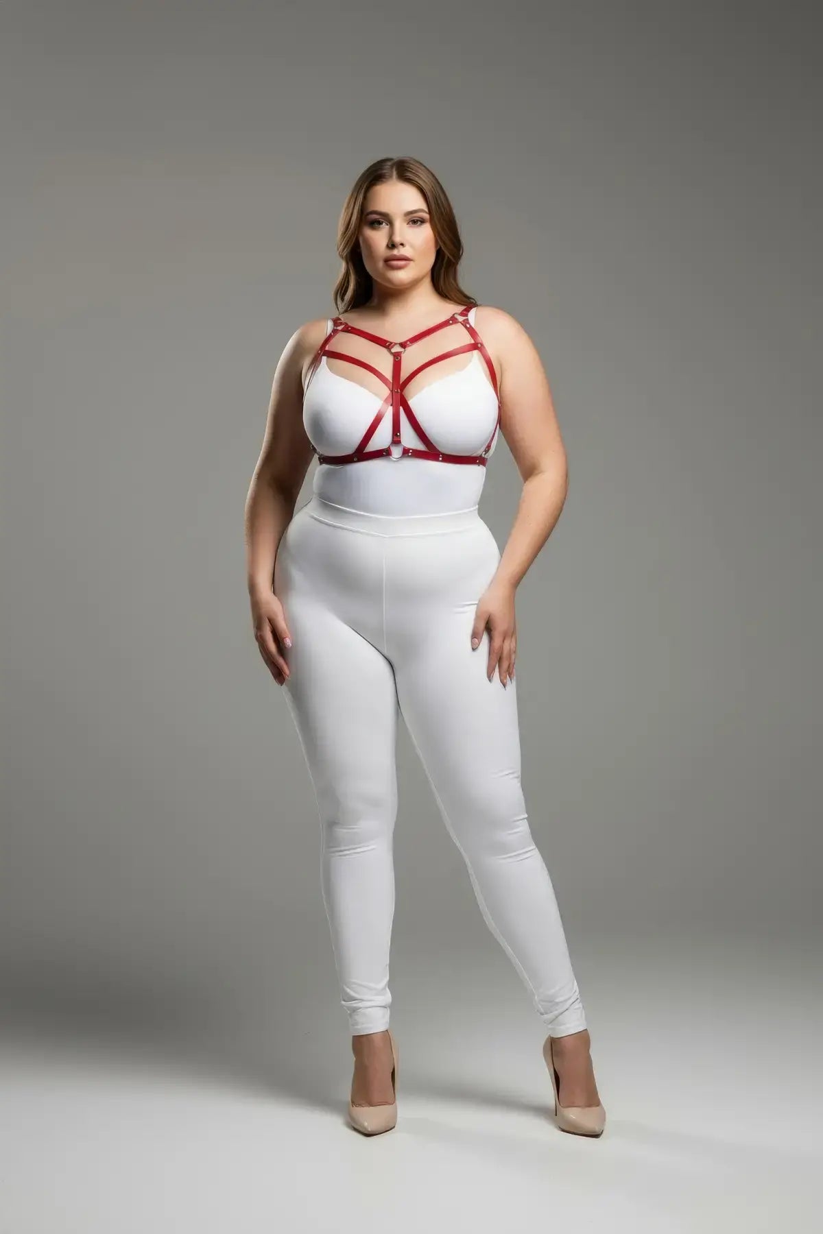Plus Size Red Cross-Strap Faux Leather Harness with geometric straps worn over a white bodysuit