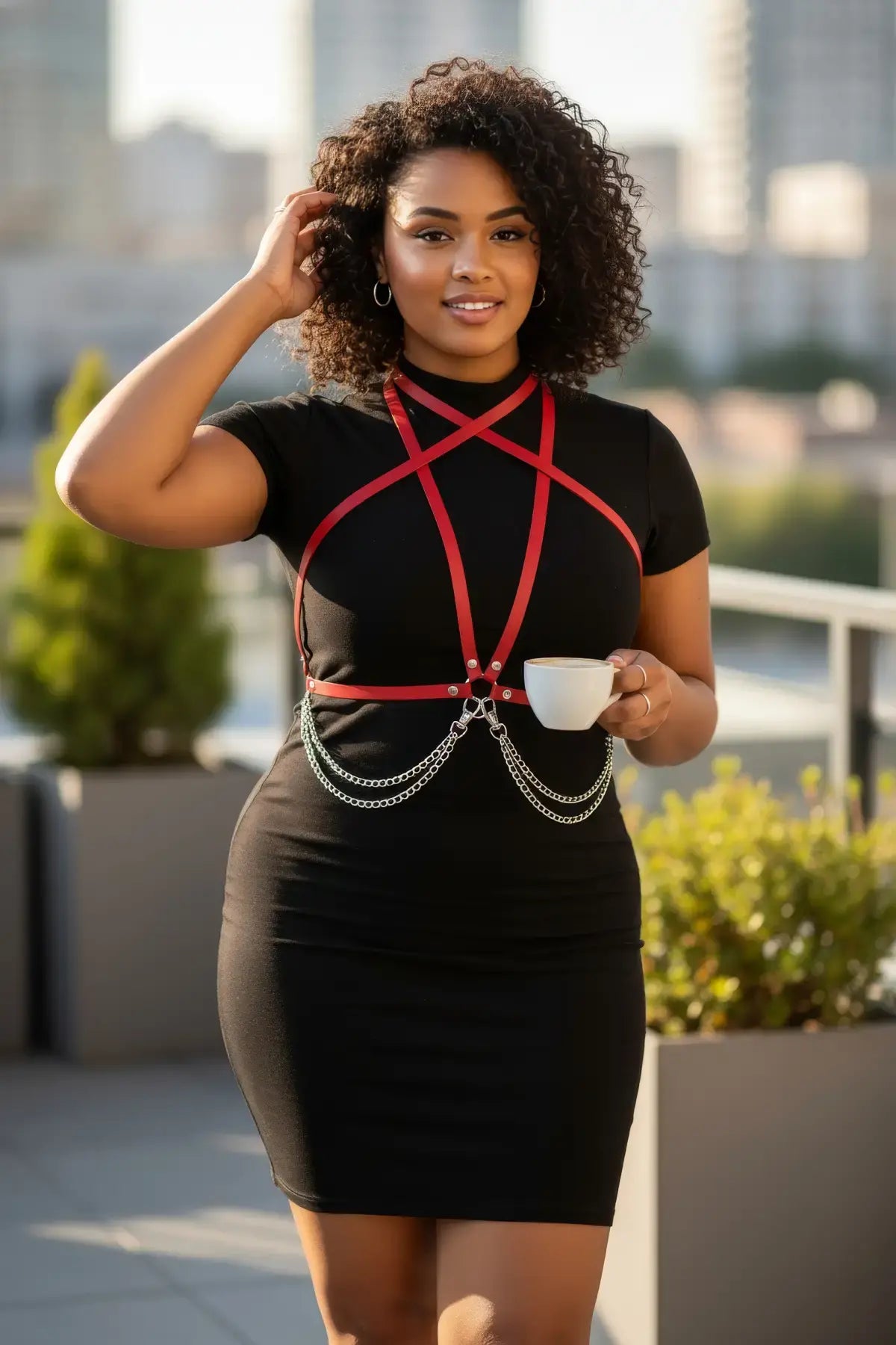 Plus size red cross-strap harness with chain drop over black dress; vegan leather body accessory