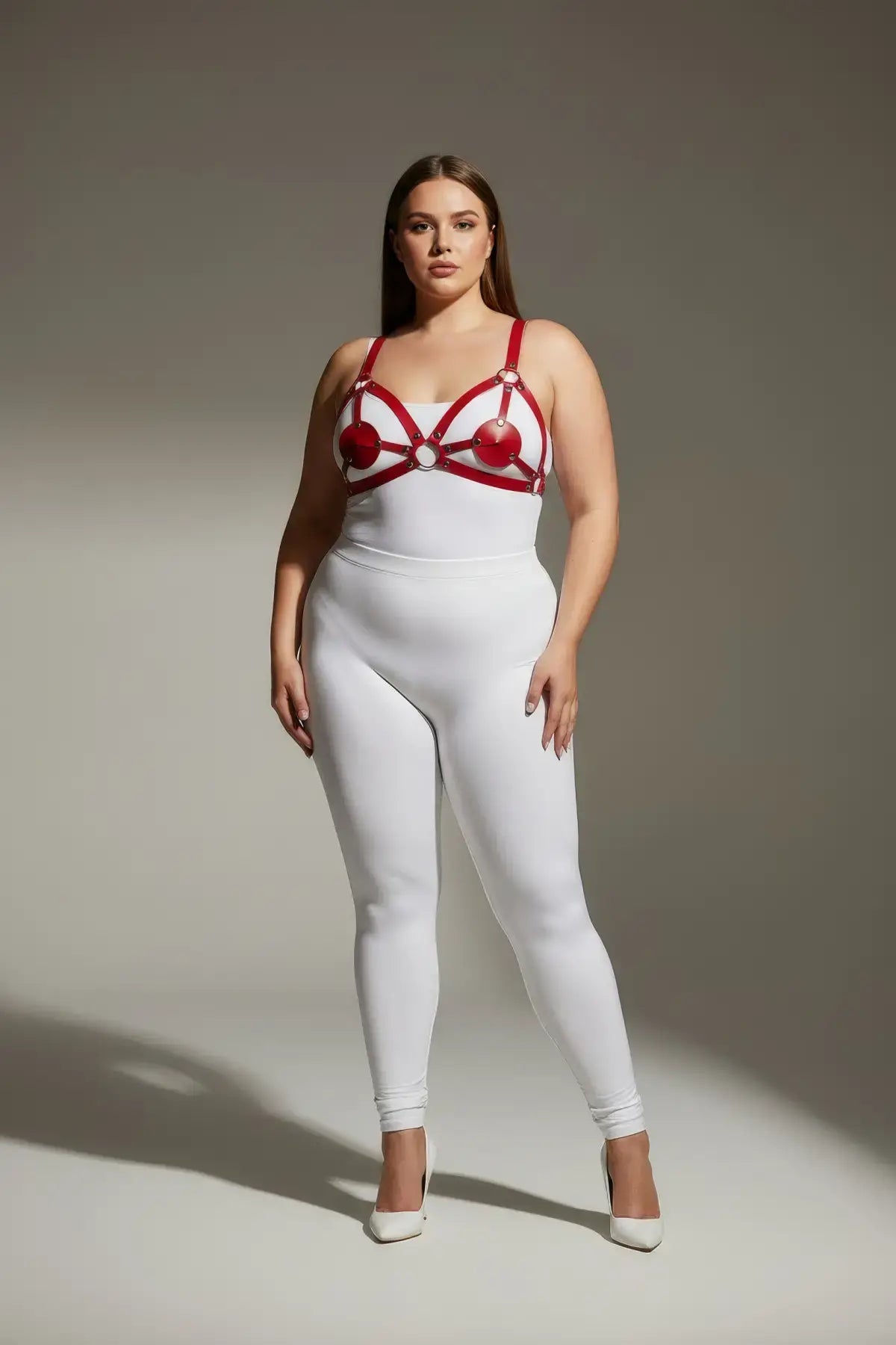 Plus-size red disc O-ring vegan leather chest harness by HarnessClub worn over white bodysuit