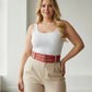 Plus size red double-row grommet belt with multiple buckles in vegan leather worn at the waist