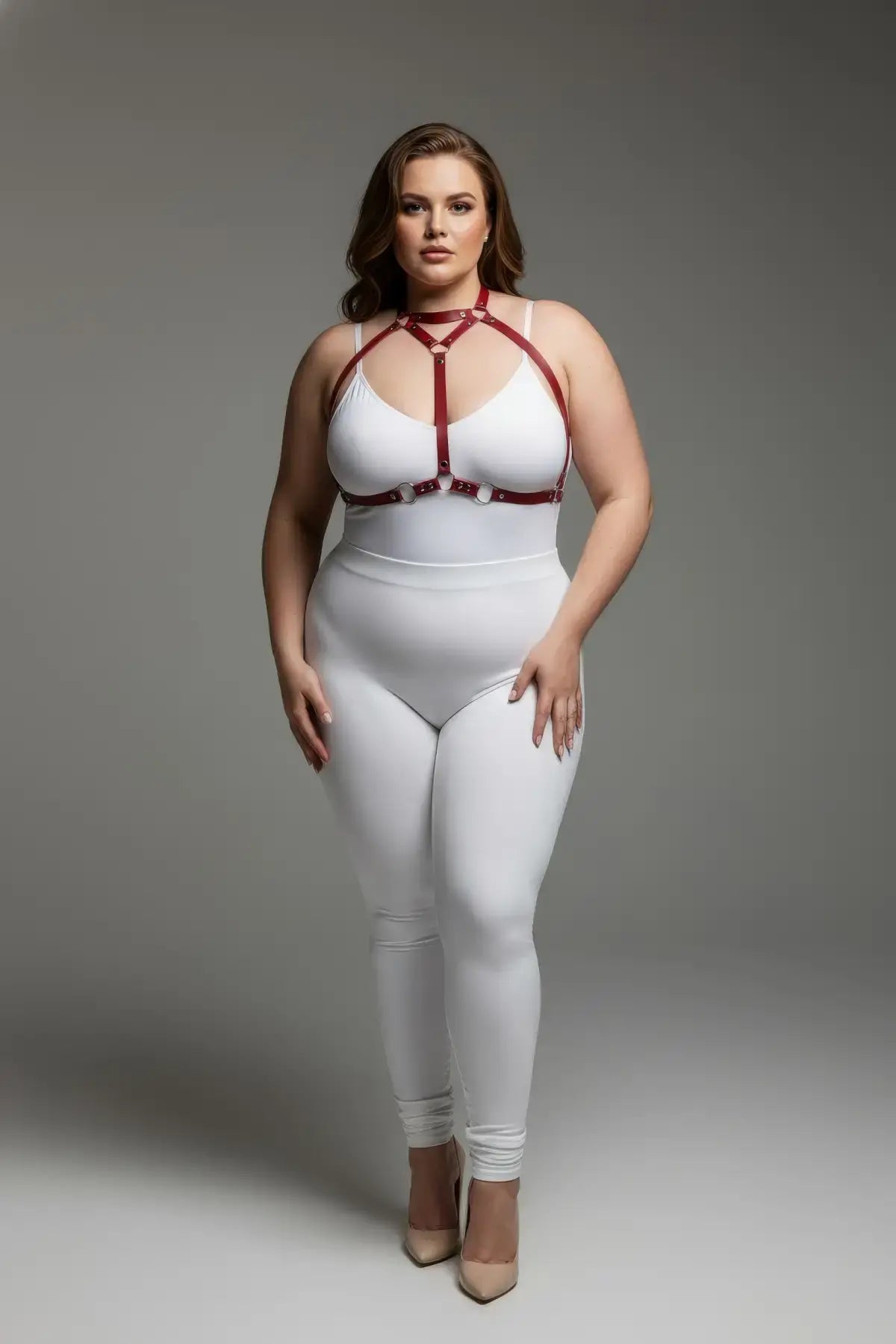 Plus-size red faux-leather body harness worn over a white bodysuit
