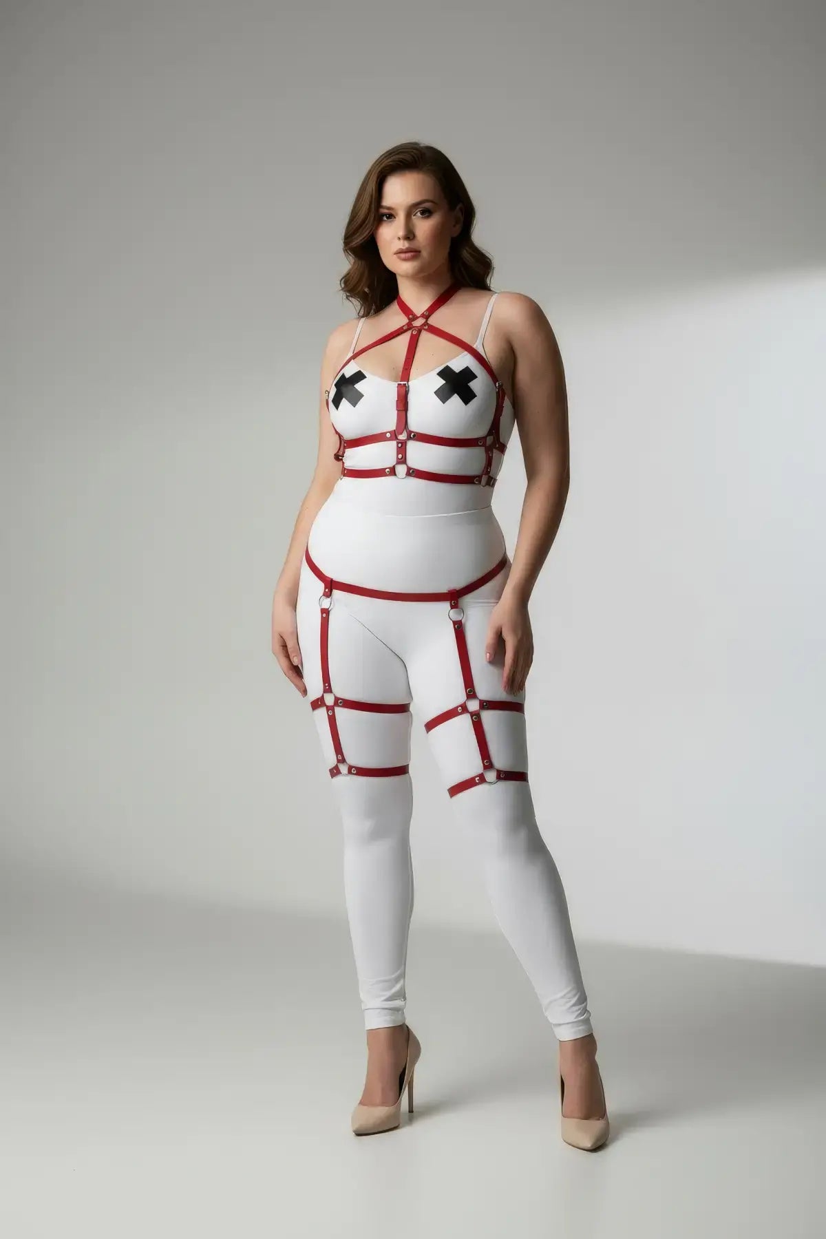 Plus-size red vegan leather garter harness body set on white bodysuit with adjustable straps.