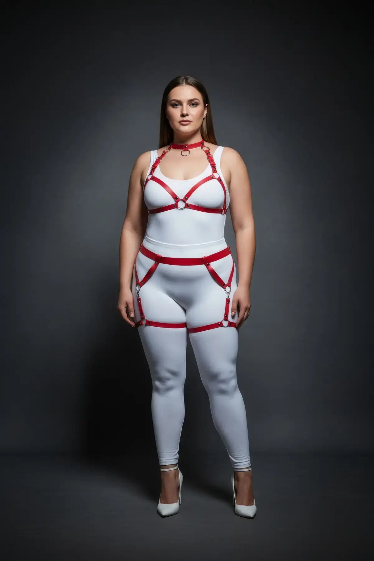 Plus-size red garter-frame full-body harness set by HarnessClub, vegan leather straps over a white bodysuit.