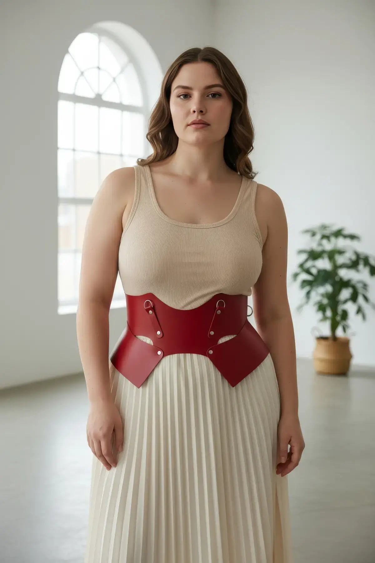 Plus-size red lace-up corset belt, vegan leather structured waist harness worn over a beige top