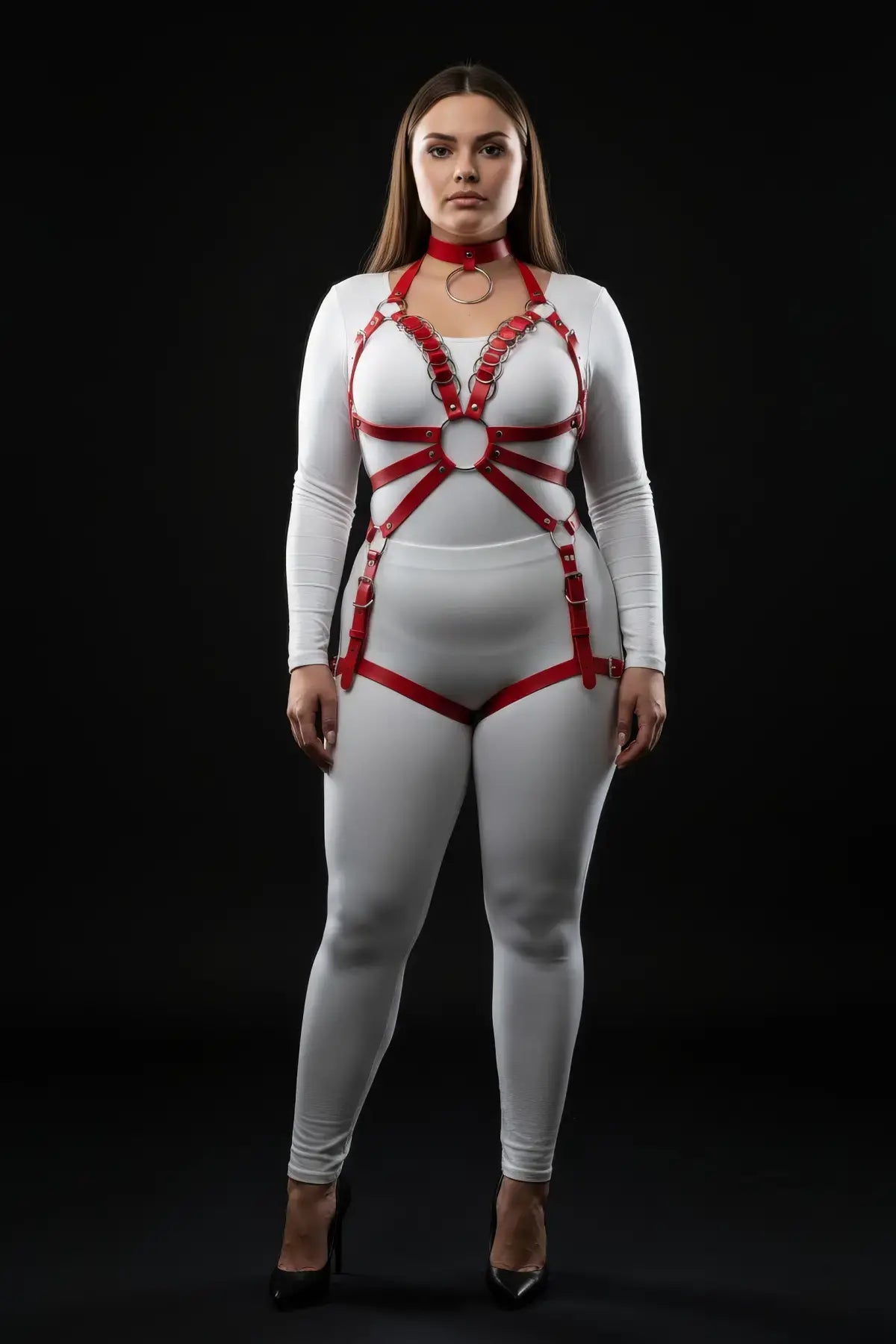 Plus-size red O-ring chain-detail body harness by HarnessClub, vegan leather worn over white bodysuit.