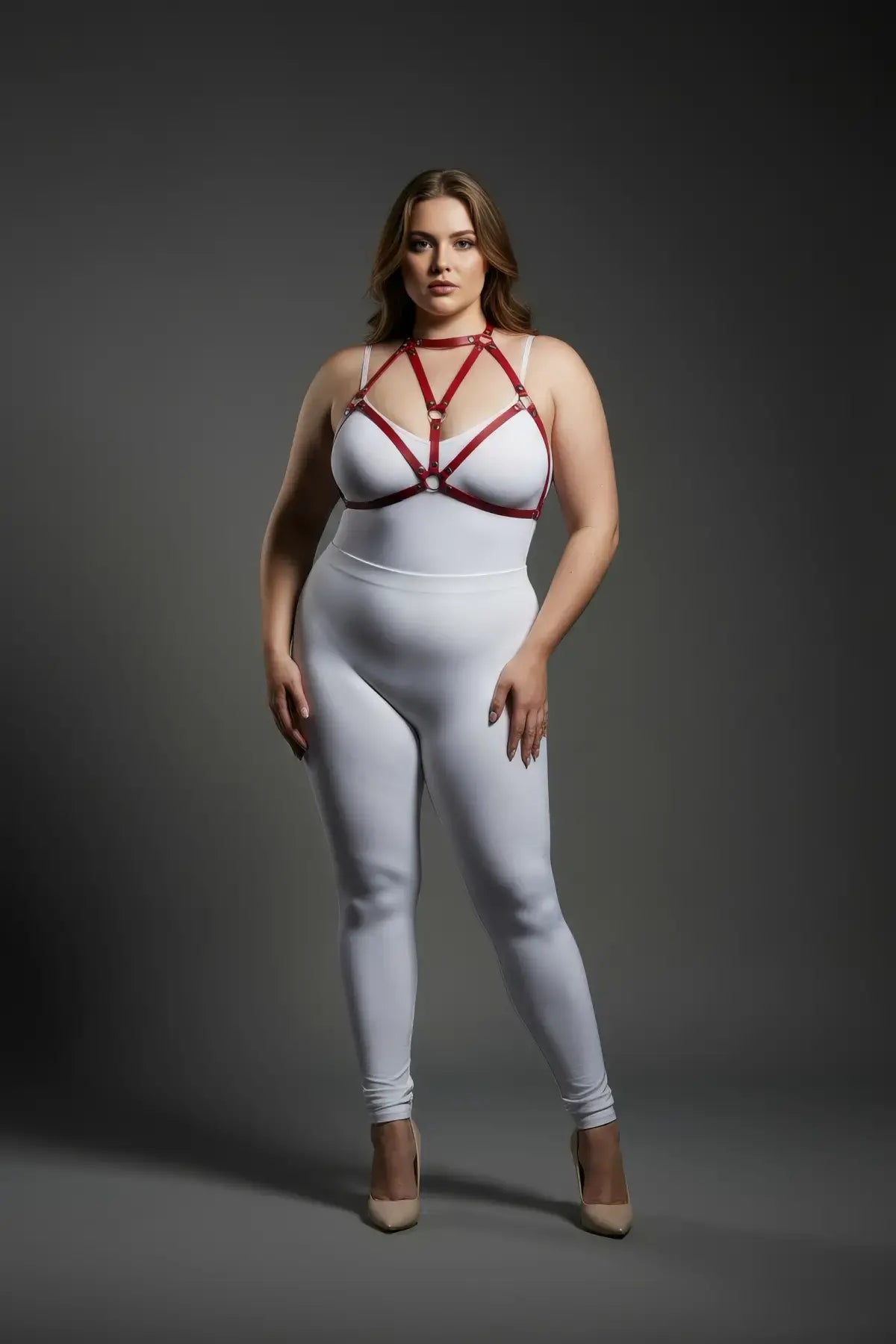 Plus-size red O-ring faux-leather body harness worn over a white bodysuit