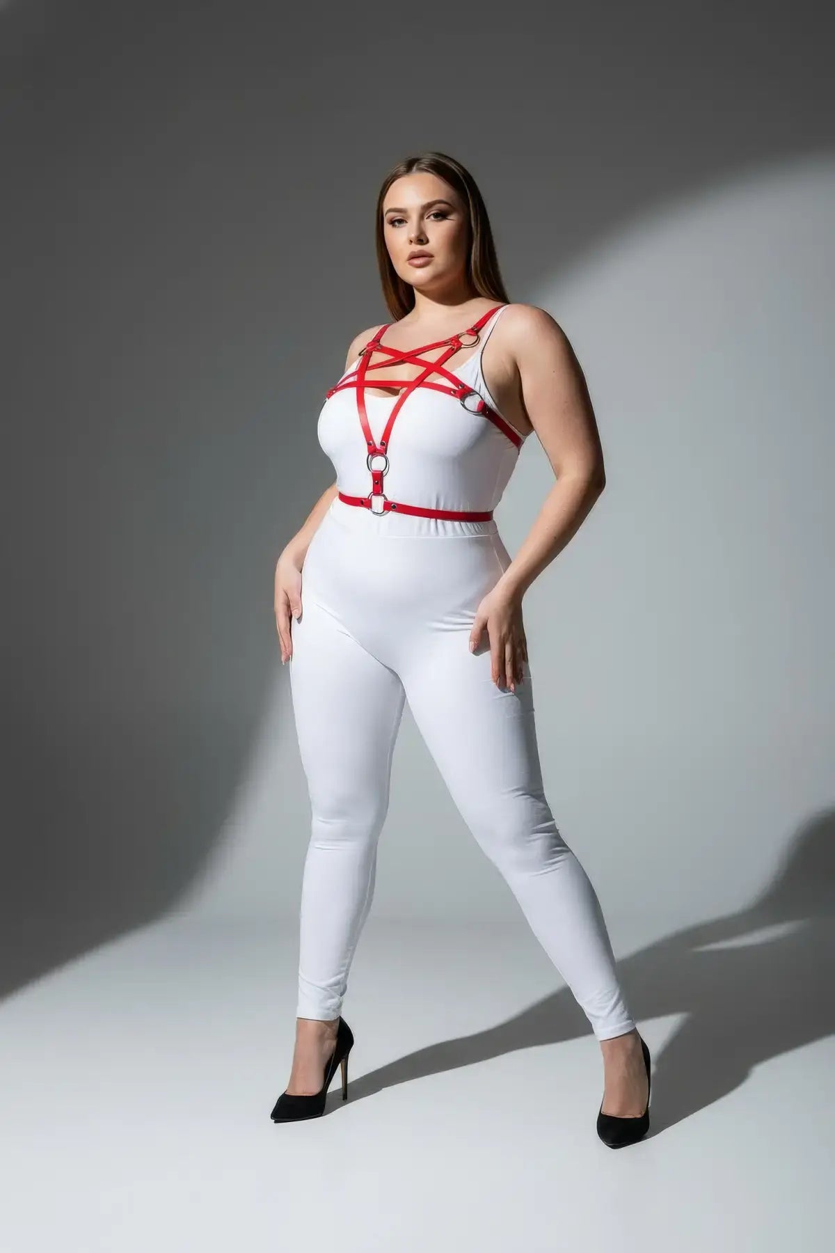 Plus-size red o-ring faux leather harness set worn over white bodysuit; four o-rings across chest.