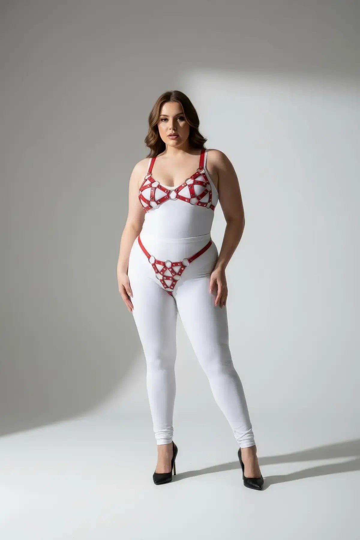 Plus-size red faux-leather O-ring body harness set on model in a white bodysuit