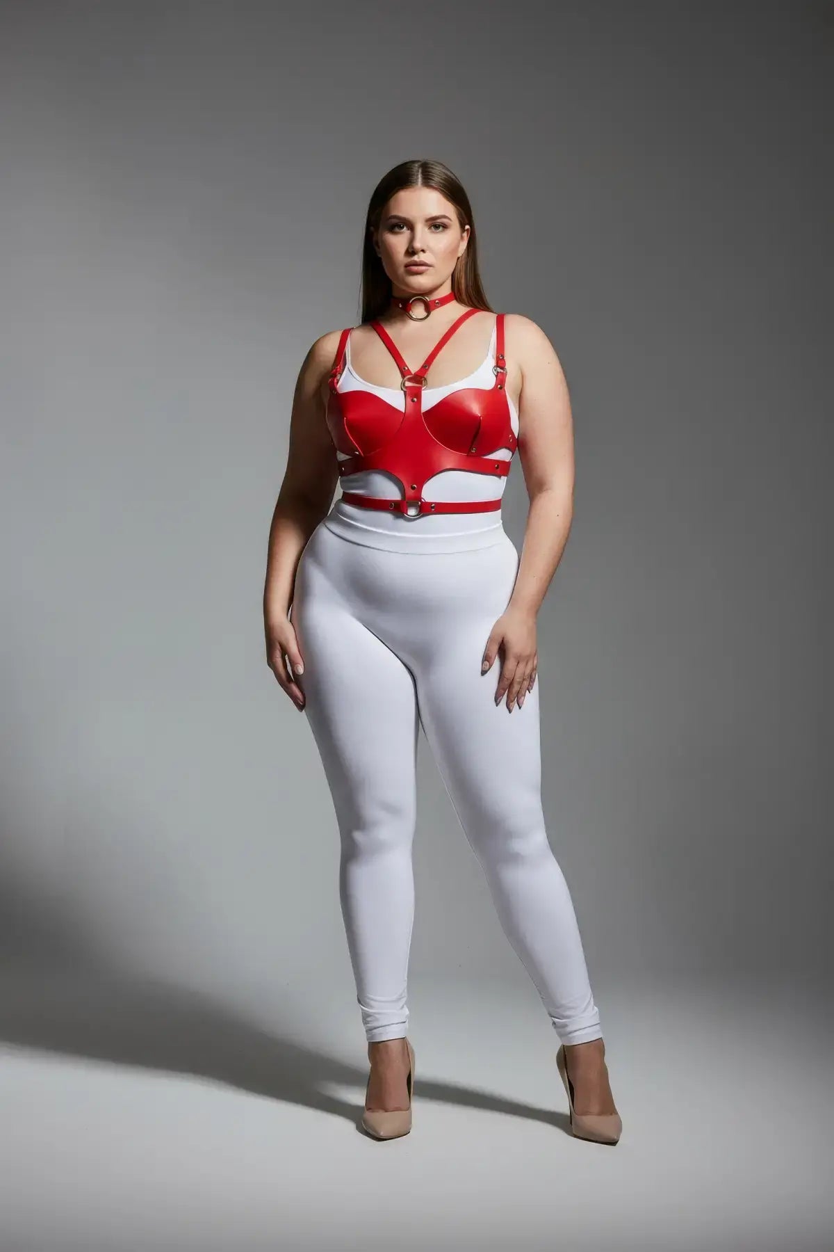 Plus-size red faux-leather chest harness with an O-ring and multiple straps worn on a model.