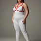 Plus-size red ring-detail elastic chest harness by HarnessClub worn over a white bodysuit.
