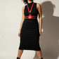 Plus-size red vegan leather shoulder harness and corset waist belt by HarnessClub, worn over a black dress.