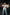 Plus-size red vegan-leather shoulder-strap corset harness worn over a white shirt.
