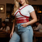 Plus-size red leather harness corset-style body accessory with shoulder straps worn over a white T-shirt
