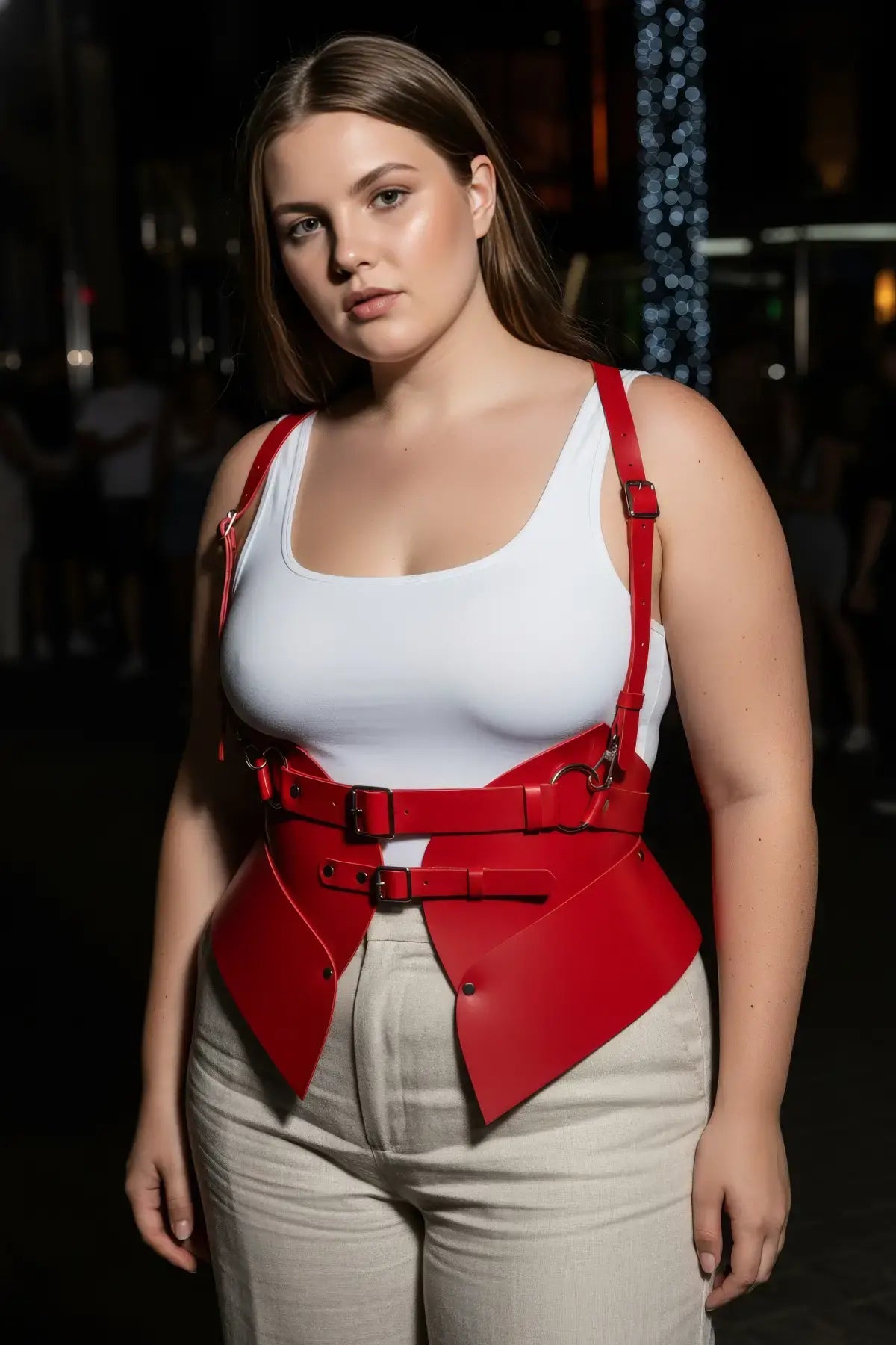 Plus-size red shoulder-harness vest in vegan leather with double buckles and peplum waist cincher