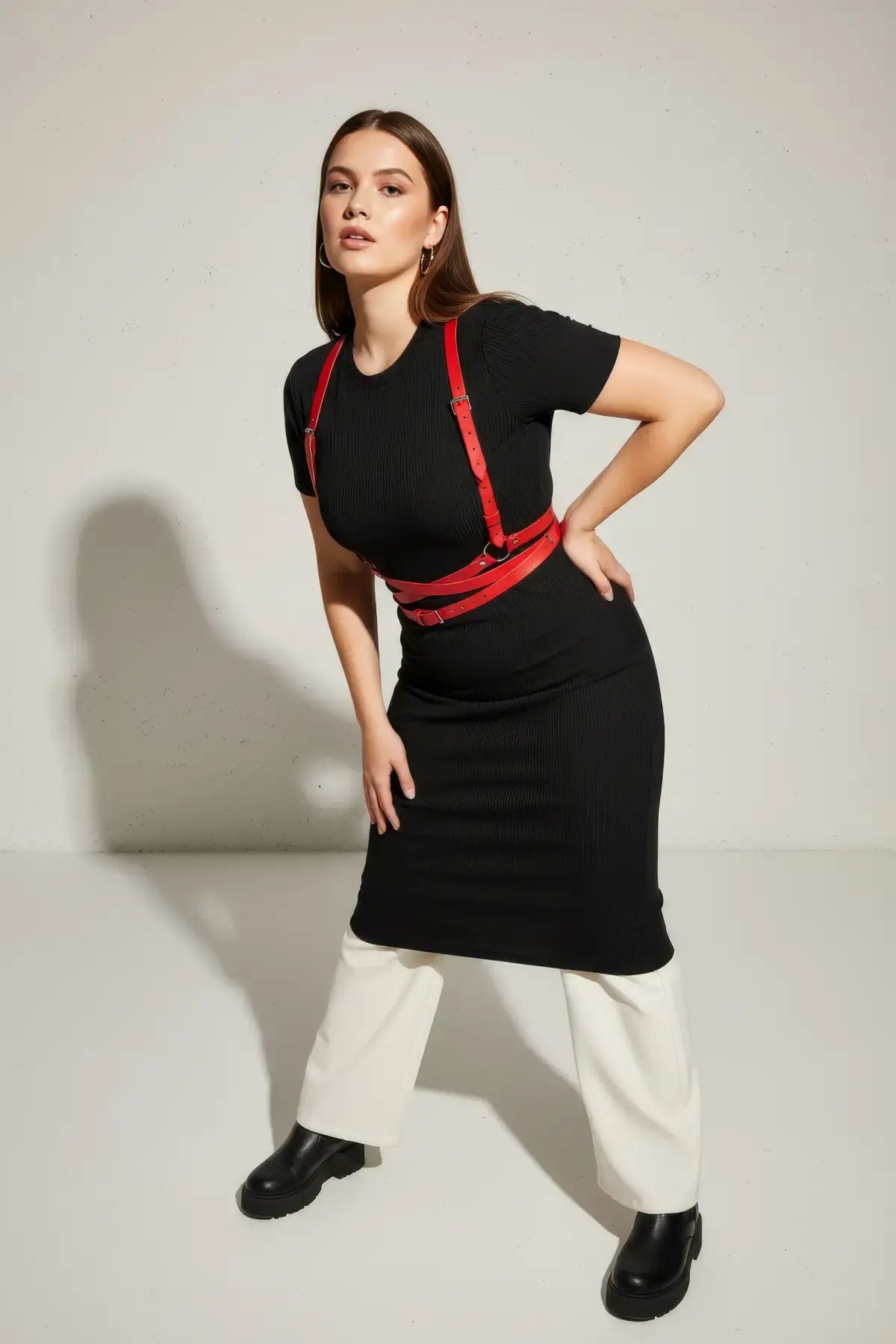 Plus-size red shoulder-strap wrap waist harness in vegan leather by HarnessClub worn over a black dress