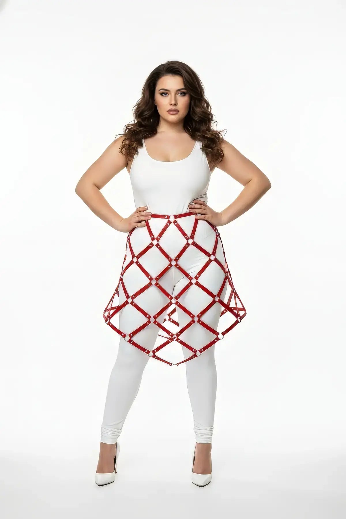Plus-size red studded lattice cage skirt worn over a white outfit; vegan leather body harness.