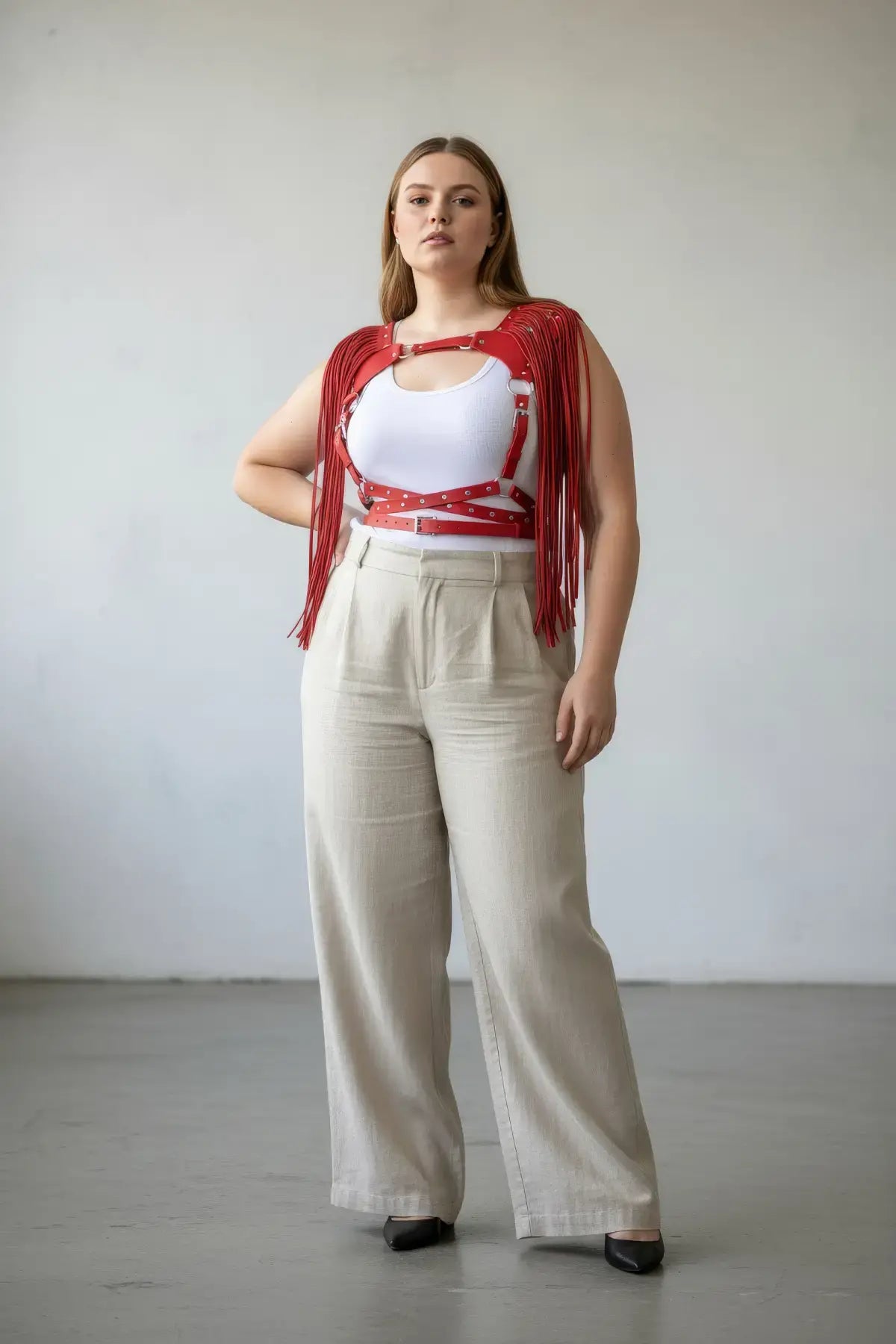 Plus Size Red Tasseled Leather Body Harness by HarnessClub, worn over a white top