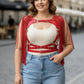 Plus-size red tasseled leather body harness on a smiling woman, featuring metal rings and buckles.