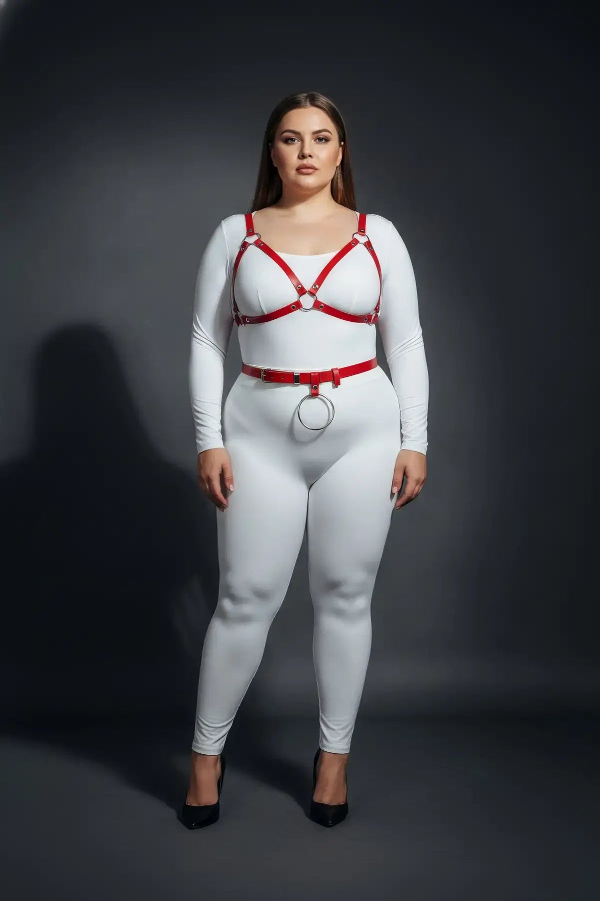Plus-size red vegan-leather V-bralette and O-ring waist belt harness set, two-piece worn over a white bodysuit