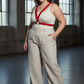 Plus-size red vegan-leather V-frame chest harness with O-ring, worn over cream ribbed tank top.