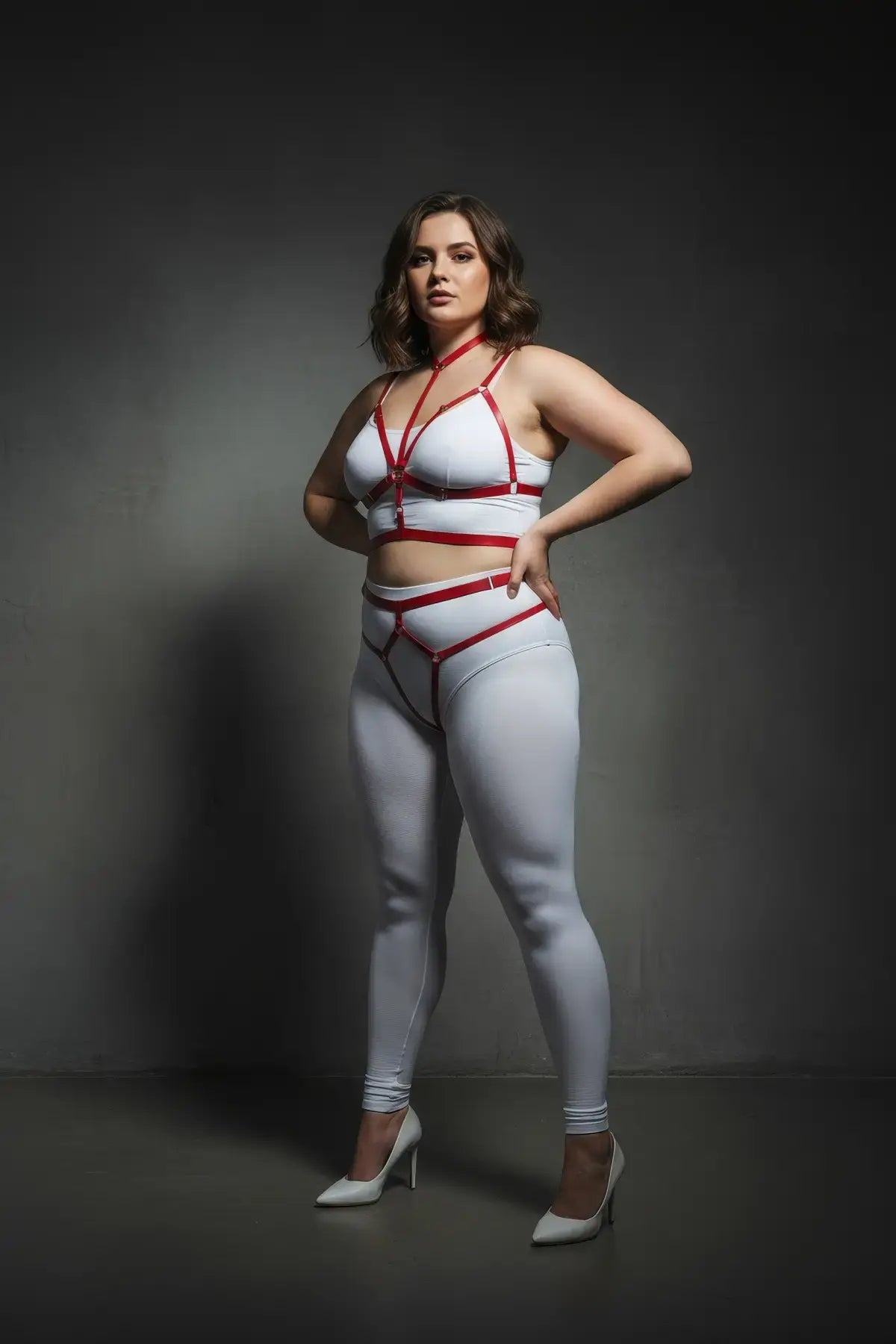 Plus-size red vegan leather harness set with collar and garter straps worn by a model