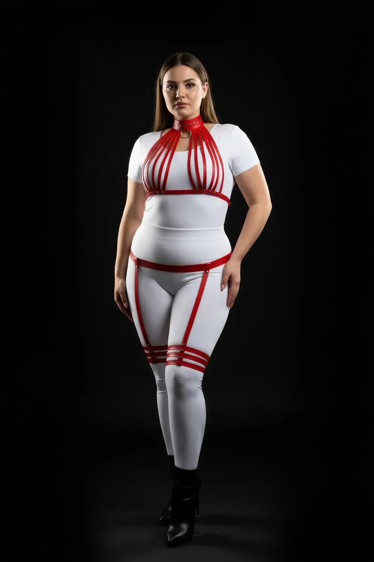 Plus-size red vertical-strap collar harness and garter thigh set in vegan leather, worn over a white base outfit.