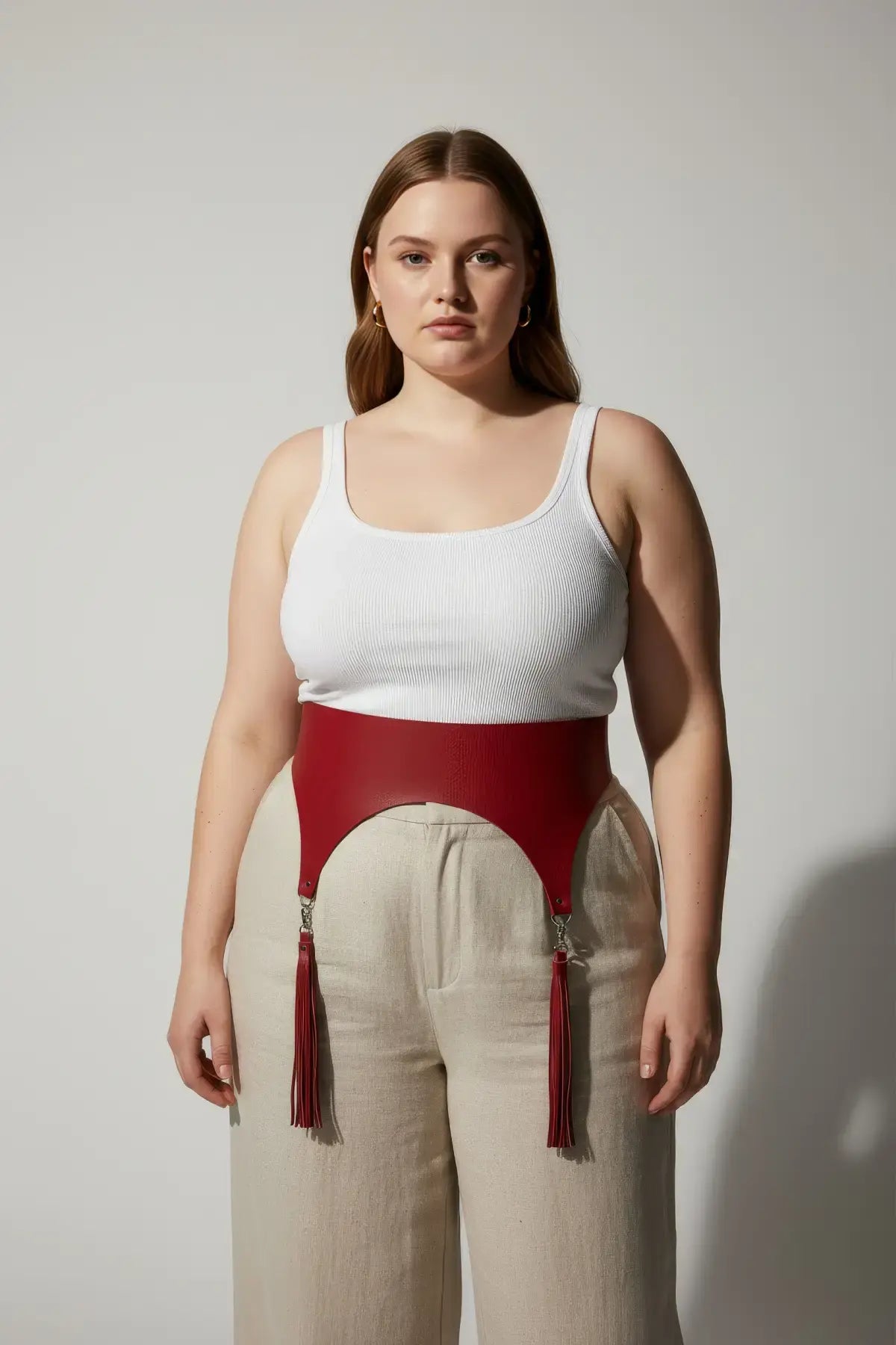Plus size red vegan leather wide corset waist belt with tassels worn by model