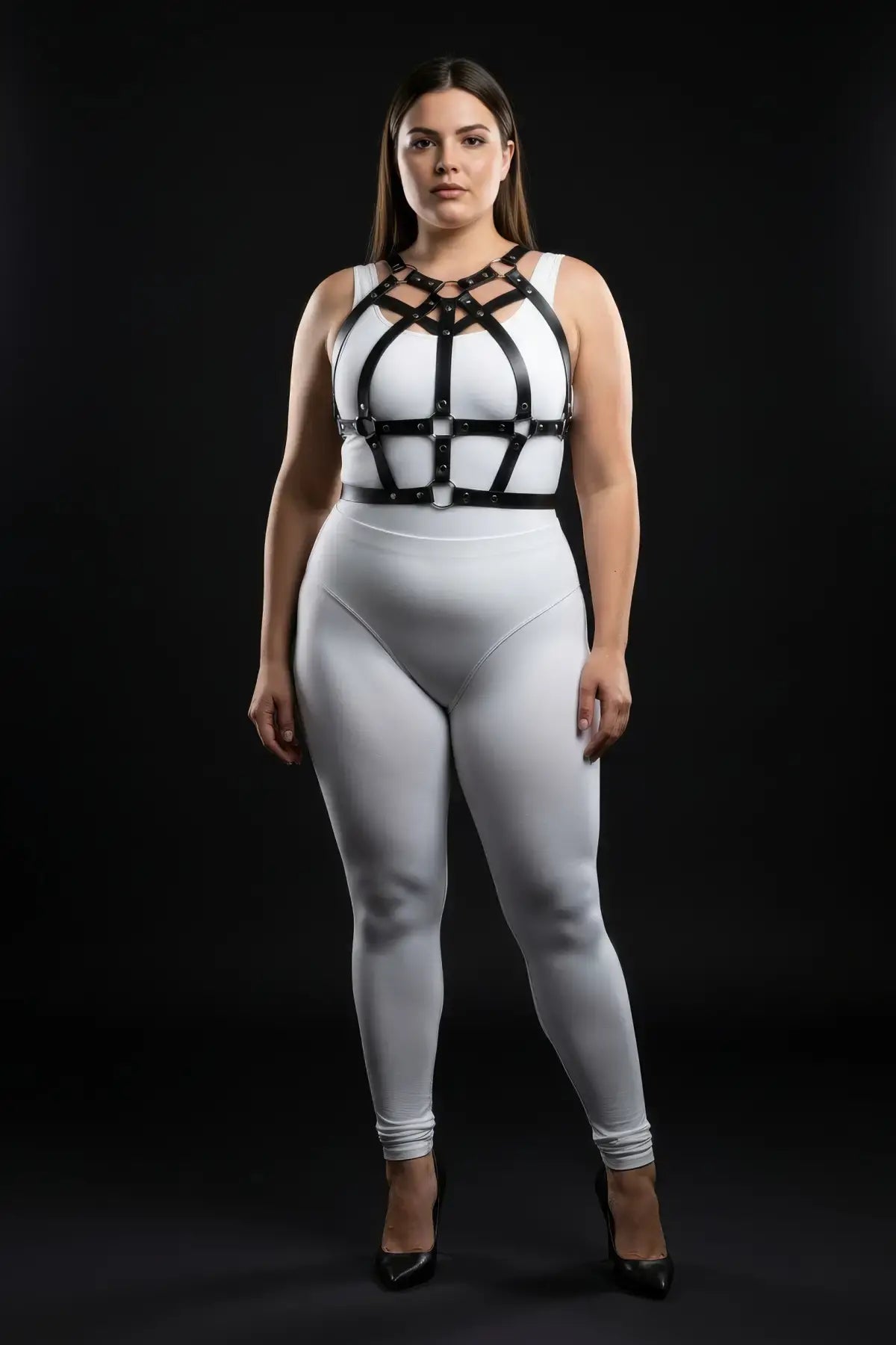 Plus size studded strap cage chest harness in black vegan leather worn over a white bodysuit