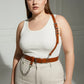 Plus-size tan genuine leather shoulder strap harness belt with chain detail worn over white tank top